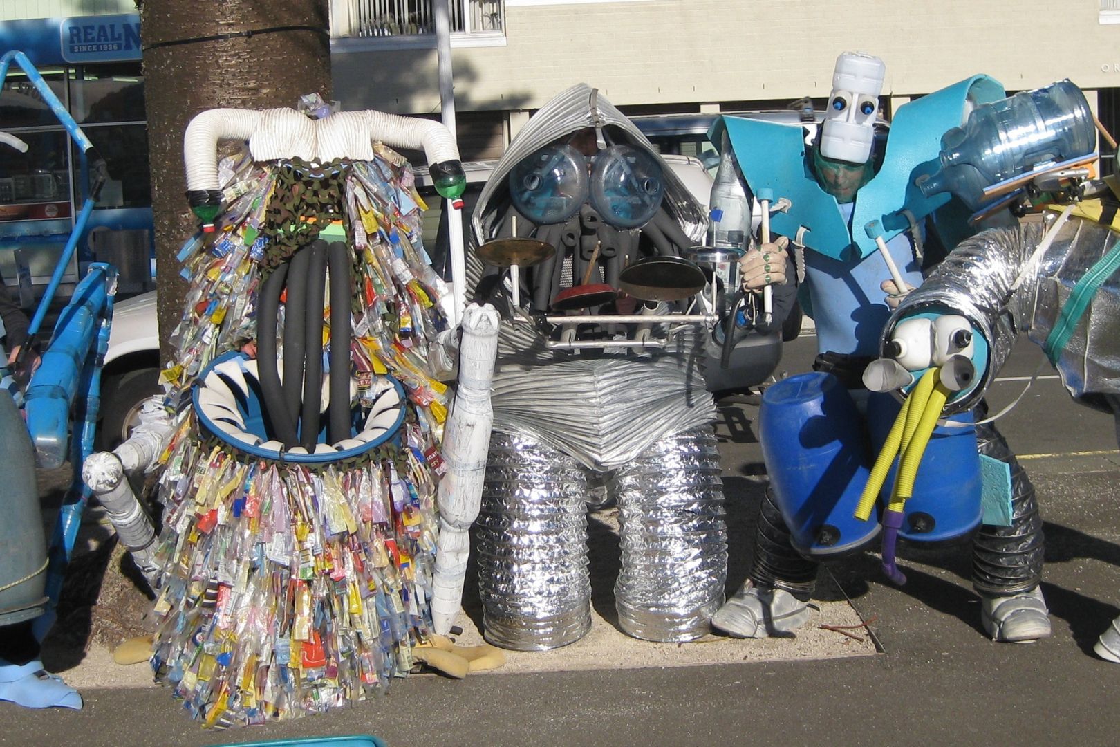 A line of people wearing full body costumes created from recycled materials.